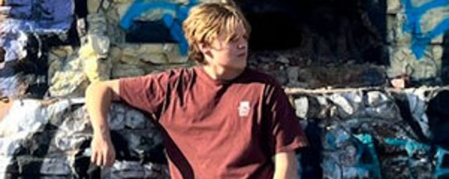 Vocalist and producer Sawyer Mitchell posing in front of a graffiti wall.